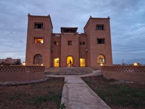un grande edificio in mattoni con scale di fronte di Hotel Kasbah Riad Amnir a Mhamid