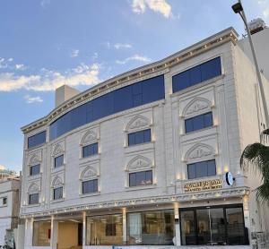 a large white building with a sign on it at شقق تارا الفندقية in Najran