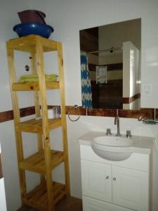 y baño con lavabo y estante de madera. en duplex playa marisol, en Balneario Oriente 9 fotos más