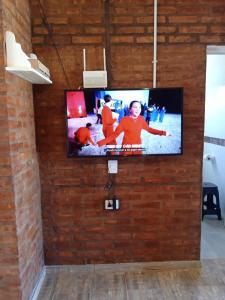 TV de pantalla plana en una pared de ladrillo en duplex playa marisol, en Balneario Oriente