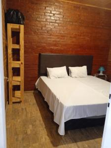 Un dormitorio con una cama y una pared de madera. en duplex playa marisol, en Balneario Oriente