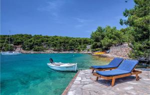 a blue chair and a boat in the water at Pet Friendly Home In Milna in Milna