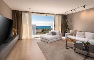a living room with white furniture and a large window at Nice Home In Pula With Kitchen in Štinjan