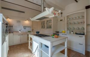 a kitchen with white cabinets and a stove top oven at 6 Bedroom Beautiful Home In Treia in Appignano
