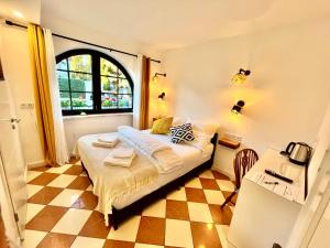 a bedroom with a bed and a table and a window at VILLA ORCHARD Frankfurt in Kriftel