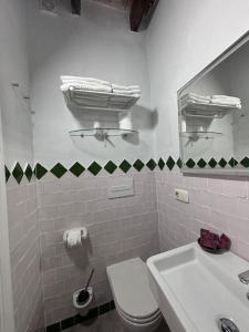 a bathroom with a toilet and a sink and a mirror at Vagamundos in Tarifa