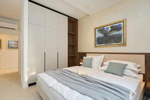 a bedroom with a large white bed with blue pillows at New & Luxury 5* with Breathtaking View- Kiki Lu Apartment in Dubrovnik