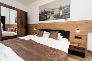 a bedroom with a large bed and a mirror at Villa Lackó - Exkluzív apartmanok in Keszthely
