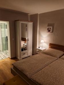 a bedroom with a bed and a cabinet with a mirror at Ferienhaus Fachwerk 97 in Stolberg