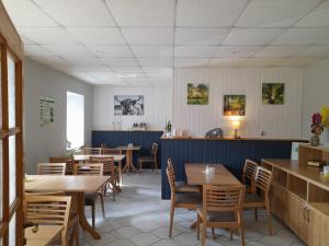 a dining room with wooden tables and chairs at Pension Redefin in Redefin
