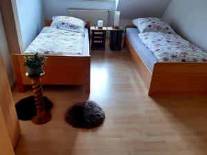 a bedroom with two beds and a plant on the floor at Ferienwohnungen "Weingenuss" für 1 bis zu 10 Personen direkt im Weingut in Sulzfeld am Main