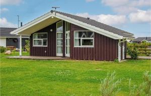 una pequeña casa con un césped verde delante de ella en Holiday Home Pøt Strandby Denk Vi, en Sønderby
