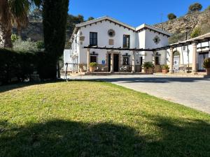 ロンダにあるHotel Rural Hacienda de Rondaの芝生の広い白い家