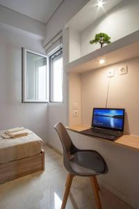 a bedroom with a desk with a laptop computer on it at Newly Renovated 2-Bedroom Condo In Athens ! in Athens