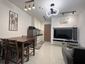 a living room with a table and a television at Bian's Cozy Suite in Kota Kinabalu