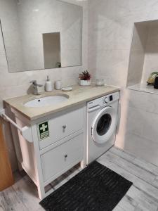 un bagno con lavandino e lavatrice di CASA do AÇÔR ad Aldeia das Dez Altre 35 foto