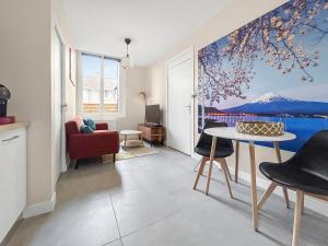 a living room with a painting on the wall at Baignoire balnéo avec climatisation in Saint-Étienne