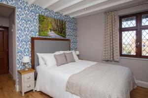 a bedroom with a bed and a blue and white wall at The Woodborough Inn in Winscombe