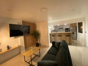a living room with a couch and a table and a kitchen at Casa Dos de Mayo in Tacna