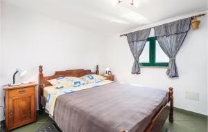 a bedroom with a bed and a window with curtains at 1 Bedroom Gorgeous Apartment In Lovran in Lovran