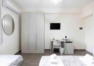 a white bedroom with a desk and a table at Affittacamere Melara in Serre