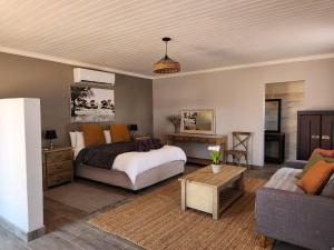 a bedroom with a bed and a couch at Jansen Kalahari Guest Farm in Hoachanas