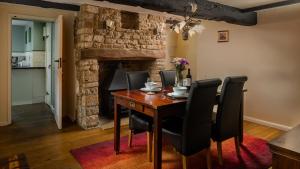 a dining room with a wooden table and black chairs at Wyck Cottage in Bourton on the Water