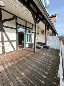 a porch of a house with a wooden deck at Ferienwohnung zur Silbertanne in Ilsenburg