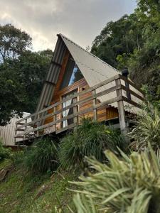 a small cabin with a pitched roof on a hill at Cabanas Bela Vista in Rolante