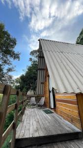 a wooden deck with a house with a fence at Cabanas Bela Vista in Rolante