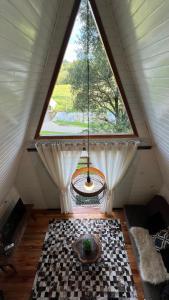 a room with a large window in a attic at Cabanas Bela Vista in Rolante
