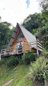 a wooden cabin with a gambrel roof on a hill at Cabanas Bela Vista in Rolante