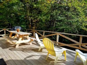 a picnic table and chairs on a wooden deck at Cozy Chalet at Jay Peak in Montgomery Center