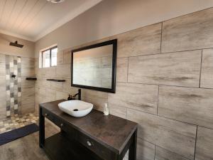 a bathroom with a sink and a mirror on a wall at Jansen Kalahari Guest Farm in Hoachanas +49 photos
