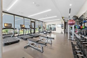 un gimnasio con una fila de cintas de correr y elípticas en Modern 1BR Condo on Rainey St with Pool and Views, en Austin