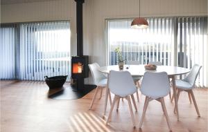 a dining room with a white table and chairs at Three-Bedroom Holiday Home In Hvide Sande in Bjerregård