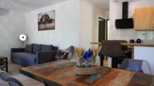 a living room with a table and a blue couch at CAP VILLAGE in Barbaste