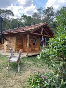 a wooden cabin with a bench in front of it at Cabana Vale Matutu in Aiuruoca