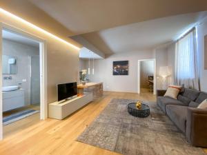 a living room with a couch and a television at Time to Be - Luxury Apartments Centro Storico in Peschiera del Garda
