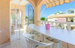 Biały stół i krzesła na balkonie w obiekcie Cozy Apartment In Torrevieja With Wifi w mieście Torrevieja