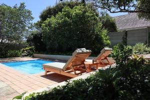two chairs and a swimming pool in a backyard at Stylish house/Heated swimming pool-5min to Beach in Wilderness