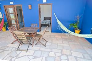 a patio with a hammock and a table and chairs at Pousada Costa Prestige in Touros