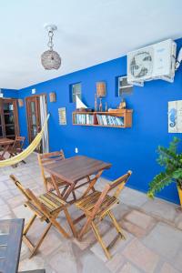 a table and chairs in a room with a blue wall at Pousada Costa Prestige in Touros
