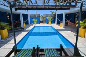 a swimming pool in a hotel with two lounge chairs at Pousada Costa Prestige in Touros