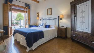 a bedroom with a bed with blue sheets and a window at Casa Rural Miel y Romero in Sevilleja de la Jara +32 photos