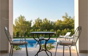 a patio with a table and two chairs and a pool at Villa Makarac in Milna