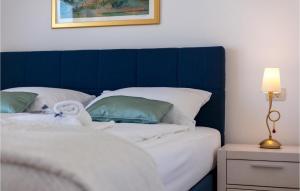 a bed with a blue headboard next to a table with a lamp at Villa Makarac in Milna +23 photos