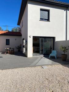 une maison blanche avec un patio et une chaise bleue dans l'établissement La contemporaine 2 chambres à Ste Marie, à Sainte-Marie-la-Mer