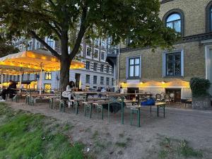 a group of tables and chairs under a tree at Central Penthouse with Private Rooftop Terrace in Copenhagen