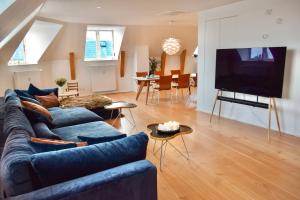 a living room with a blue couch and a tv at Central Penthouse with Private Rooftop Terrace in Copenhagen